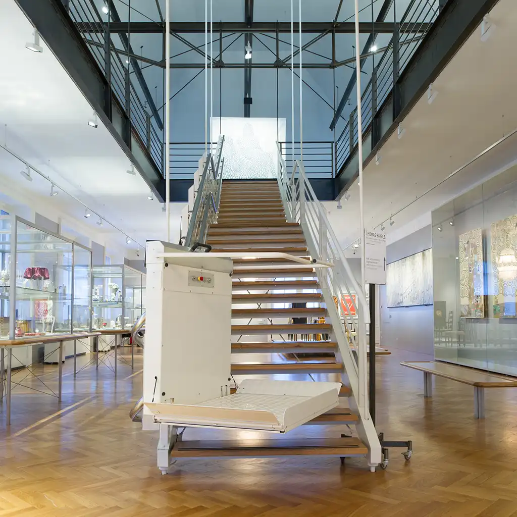 Plattformlift an moderner Treppe in einem öffentlichen Gebäude