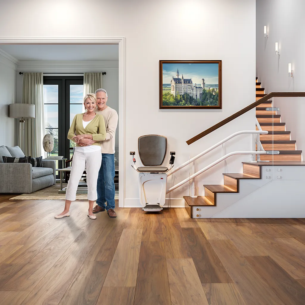 Modernes Haus mit Treppenlift an einer Holztreppe, Paar steht daneben